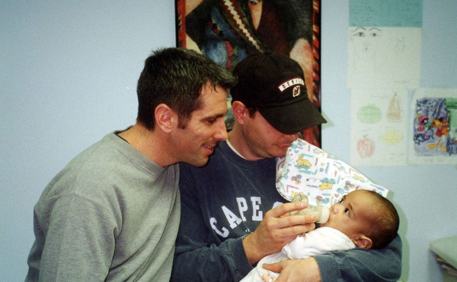 A picture of Danny and Peter feeding baby Kevin at the hospital.