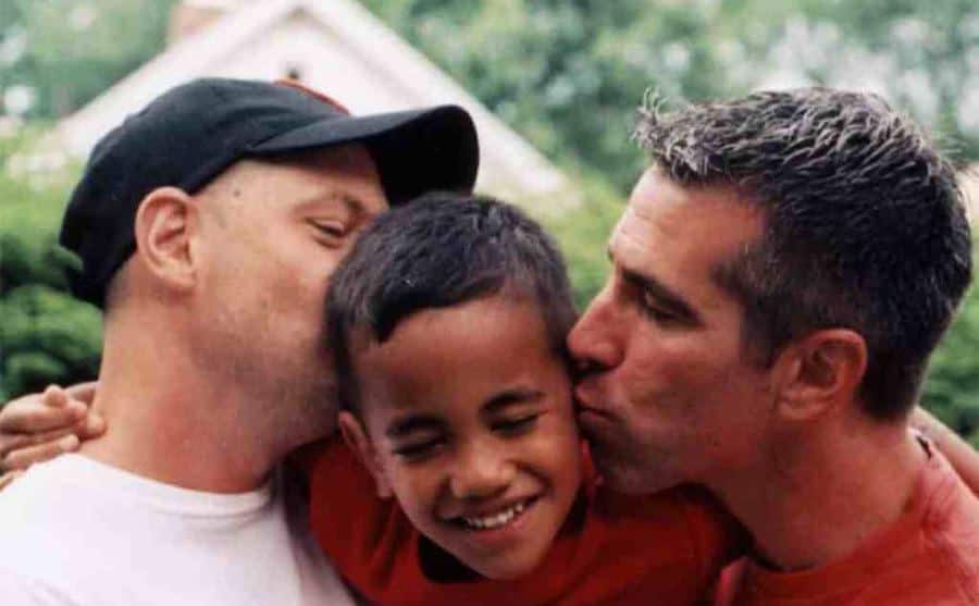 A photo of Peter and Danny kissing their son.
