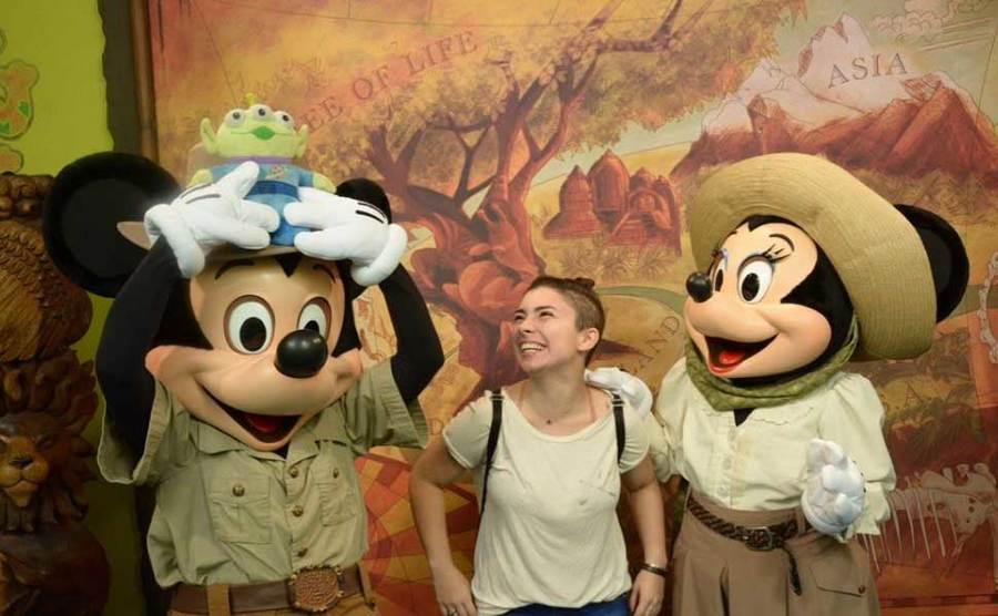 A woman takes a photo with Mickie and Minnie. 