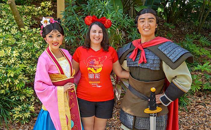 A guest poses with characters from the park. 