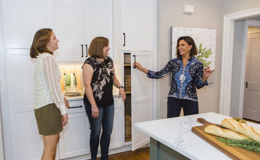 Hilary shows off the kitchen to a couple of women. 