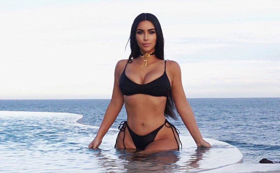 Kim is seen walking out of a pool. 