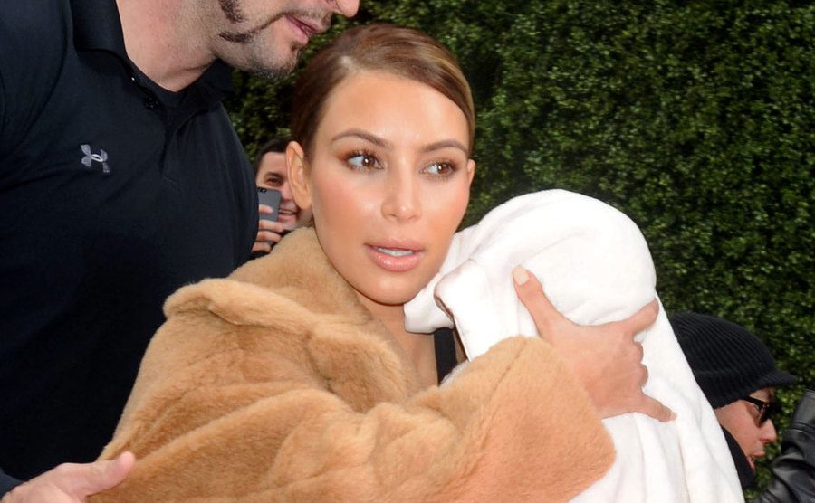 Kim Kardashian carries her baby North West. 
