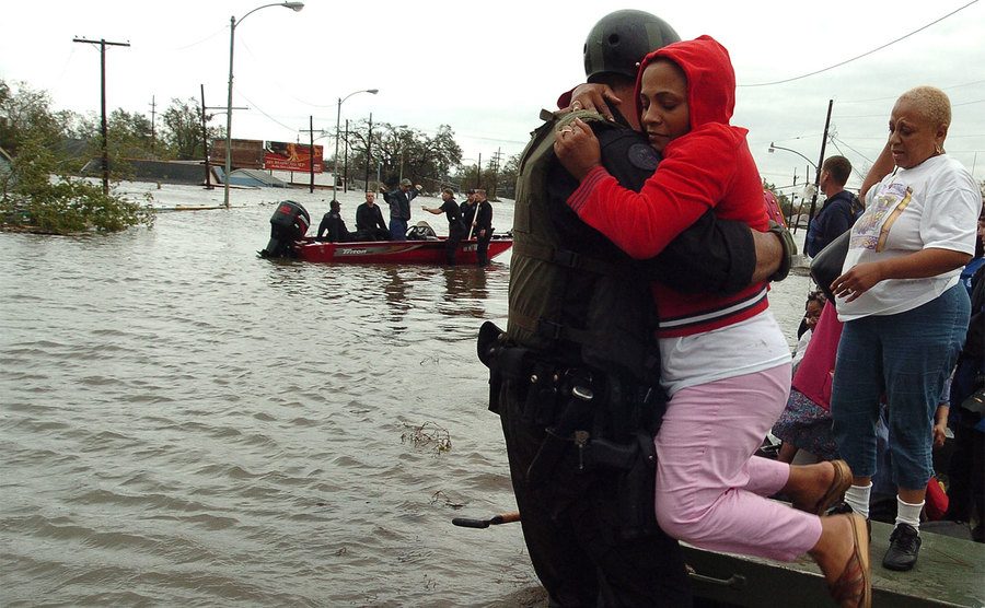 New Orleans police bring people ashore from rescue boats. 